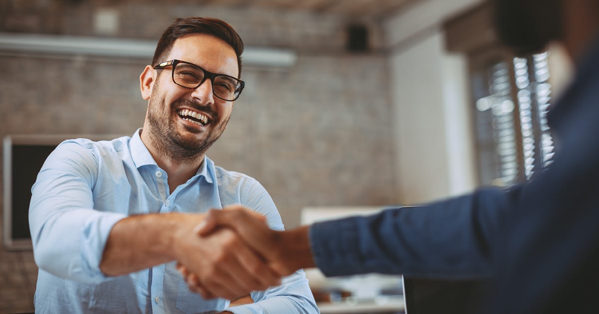 Business owner shaking hands with trading partner, building relationships