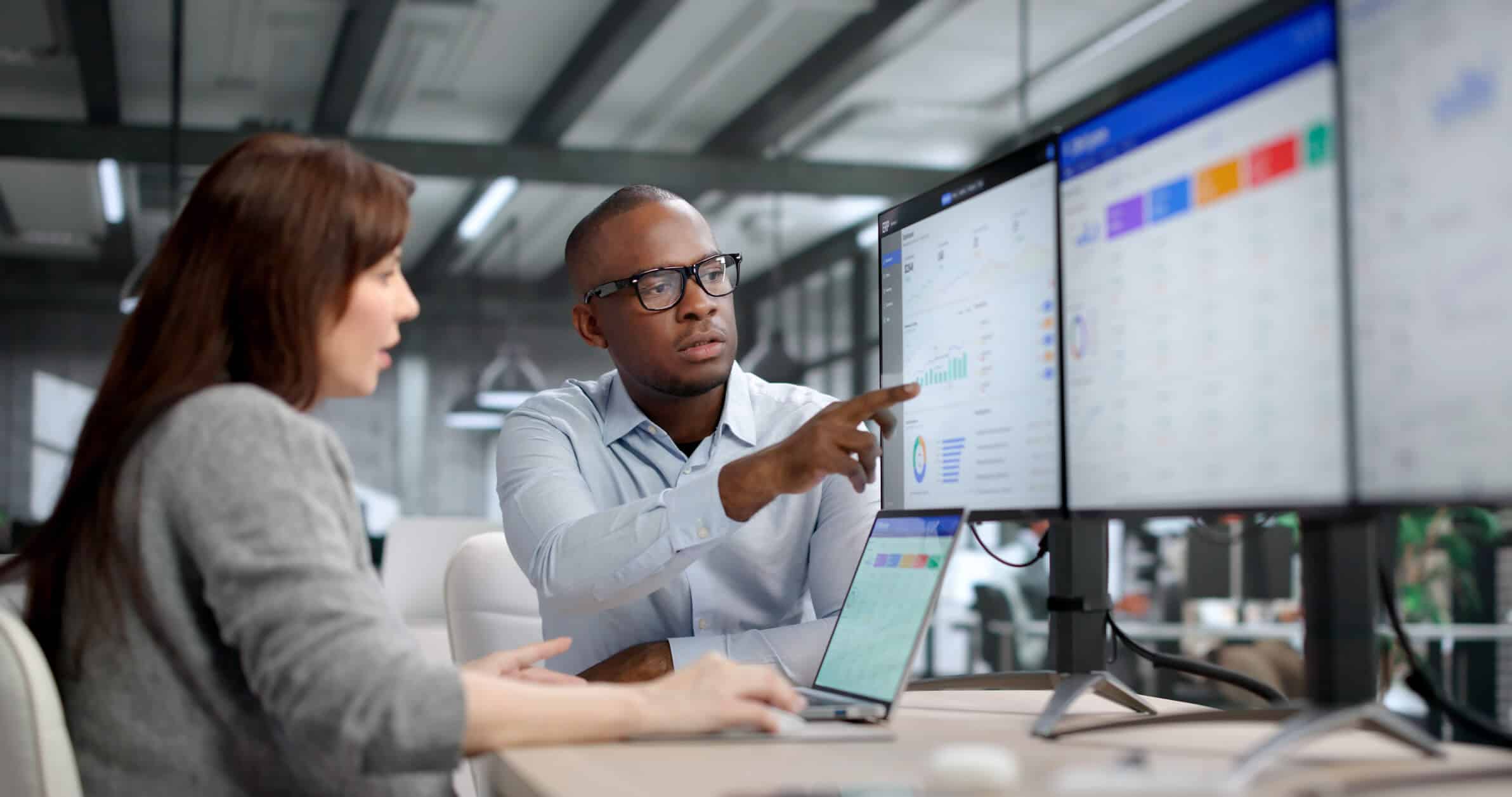 Zwei junge Fachkräfte arbeiten gemeinsam an ERP- und CRM-Software