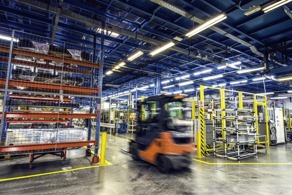 Forklift driving around in a factory.