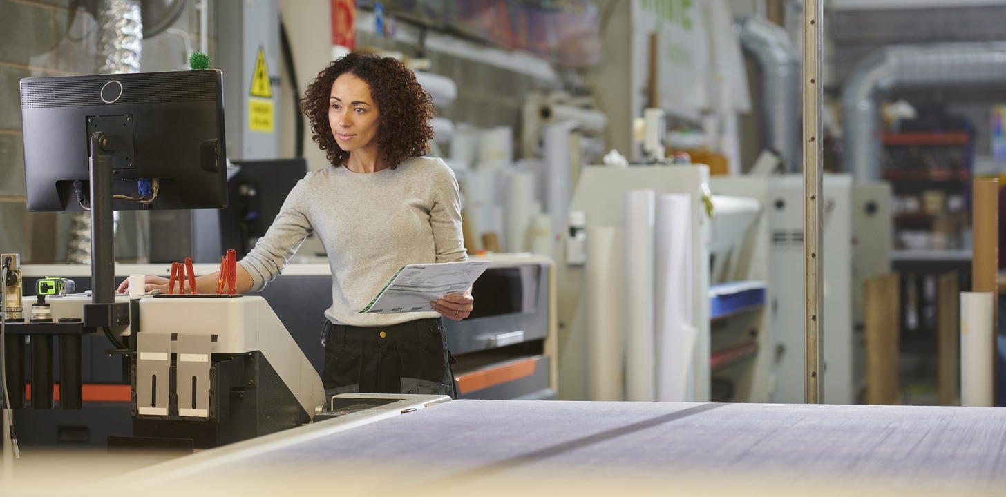 Frau, die eine CNC-Maschine programmiert