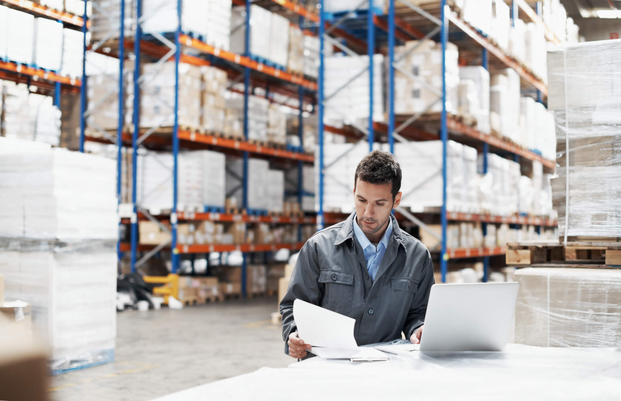 Man on laptop in warehouse