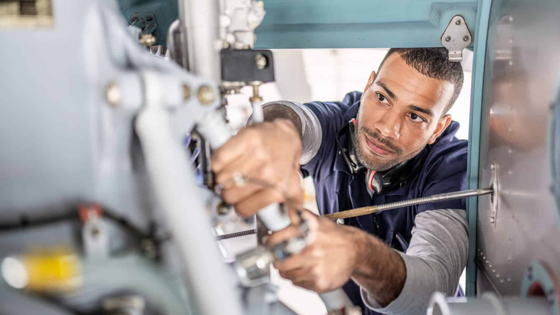 Flugzeugmechaniker bei der Reparatur eines Jets, Blick ins Innere des Triebwerks