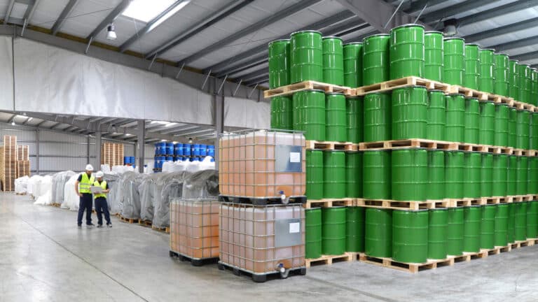Eine Gruppe von Beschäftigten aus der Logistikbranche arbeitet in einem Lager mit Chemikalien.