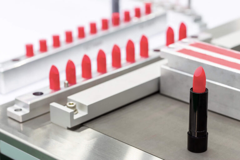 Eine Abfüllmaschine für Lippenstift-Tuben in einer Kosmetikfabrik.