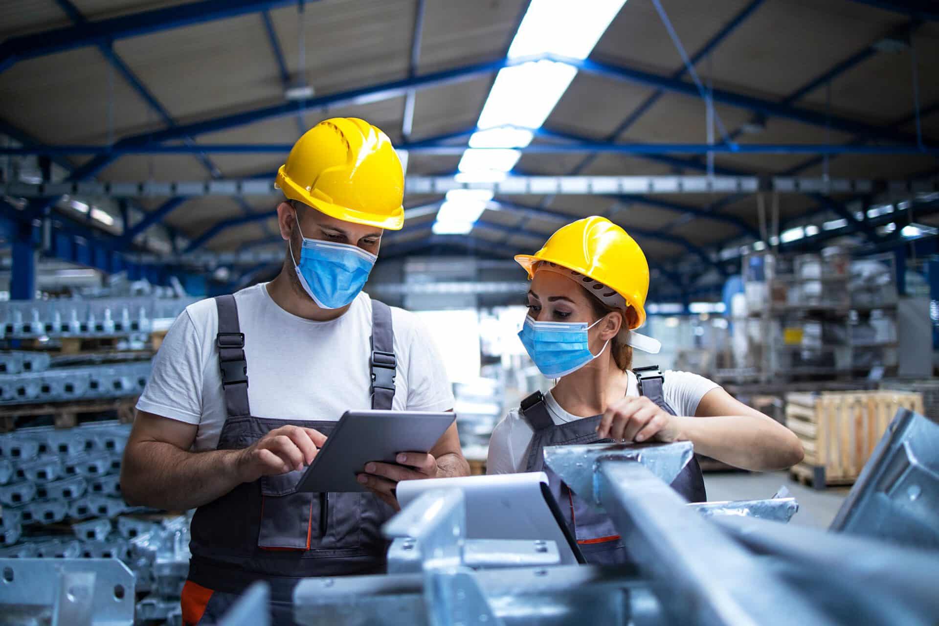 factory workers looking at a tablet