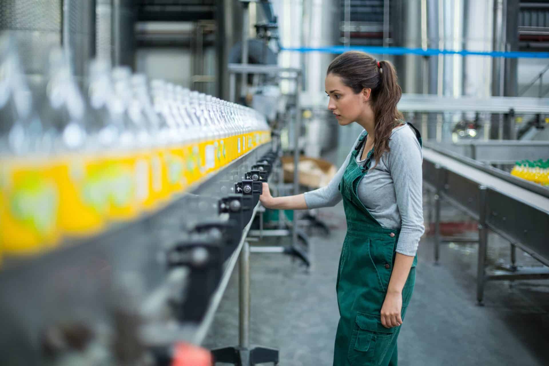 Woman at bottling line in manufacturing plant