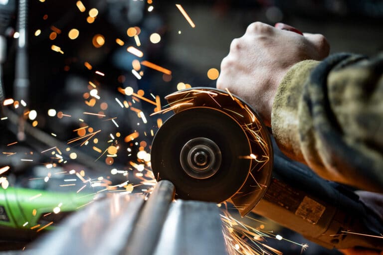Techniker mit Handschuhen bei der Bestückung einer Leiterplatte an einer modernen SMT-Fertigungslinie