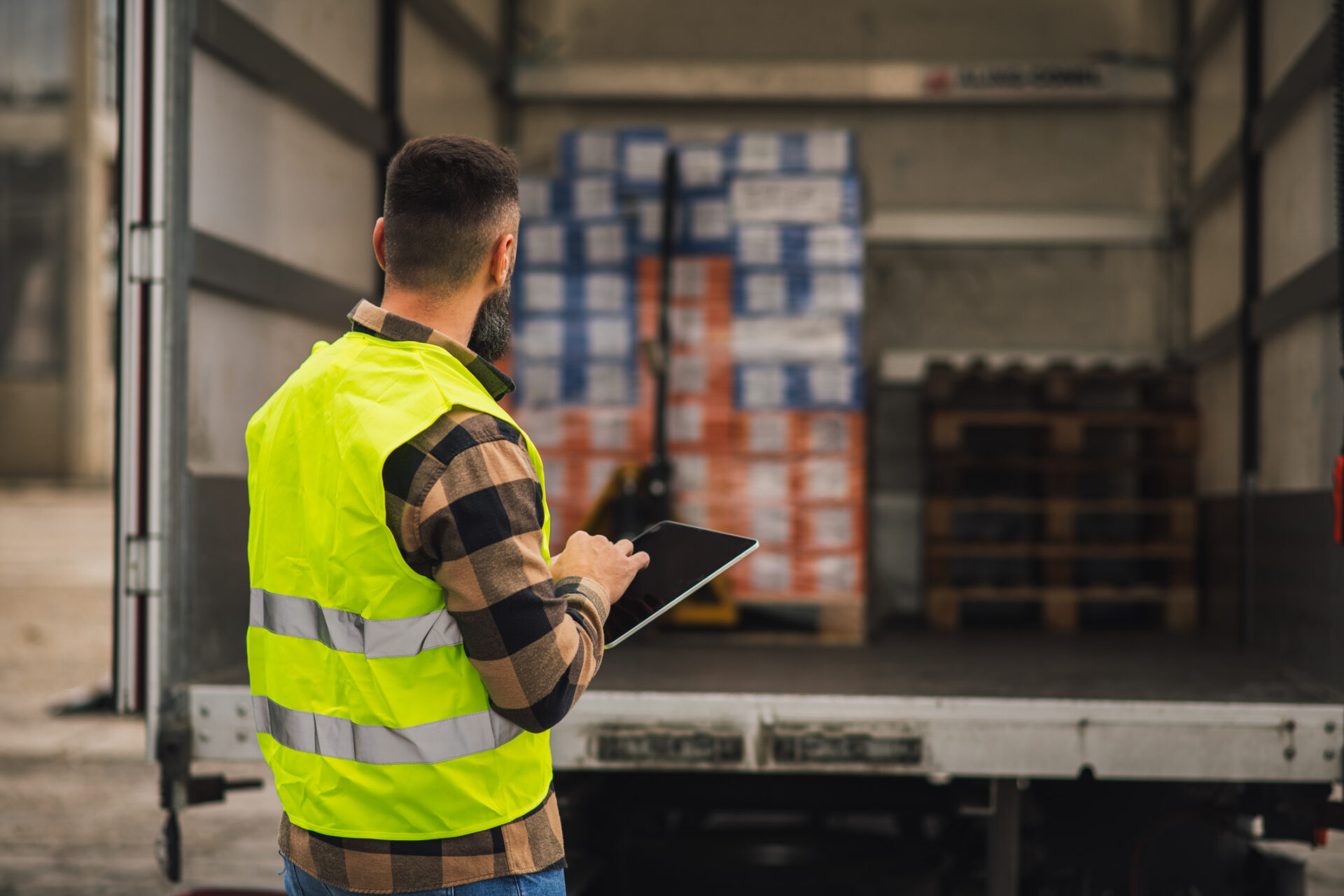 Lagerlogistiker, der Versanddaten auf einem Tablet einscannt