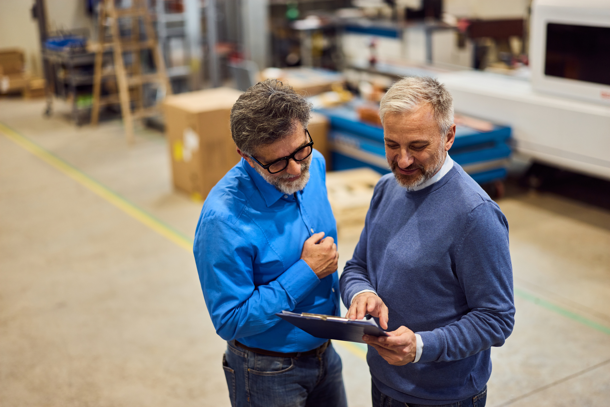 Dos compañeros de trabajo comentan detalles del trabajo en un taller industrial