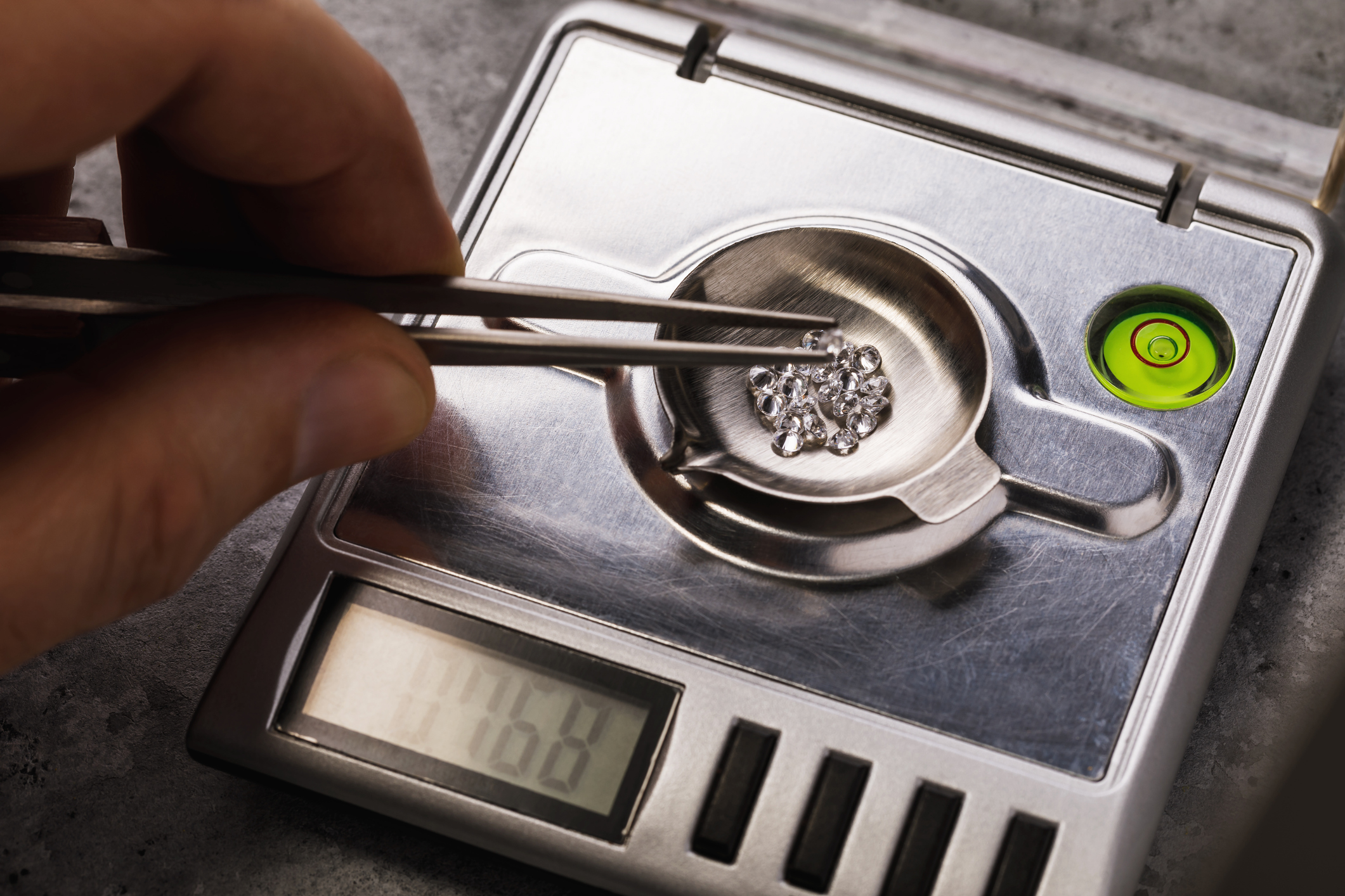 Master measures the weight of gemstones on jewelry scales, closeup