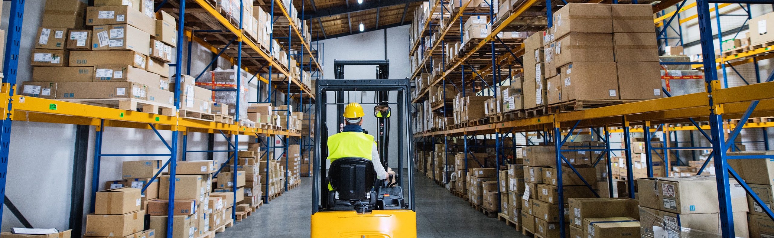 worker on forklift moving product in a warehouse facility