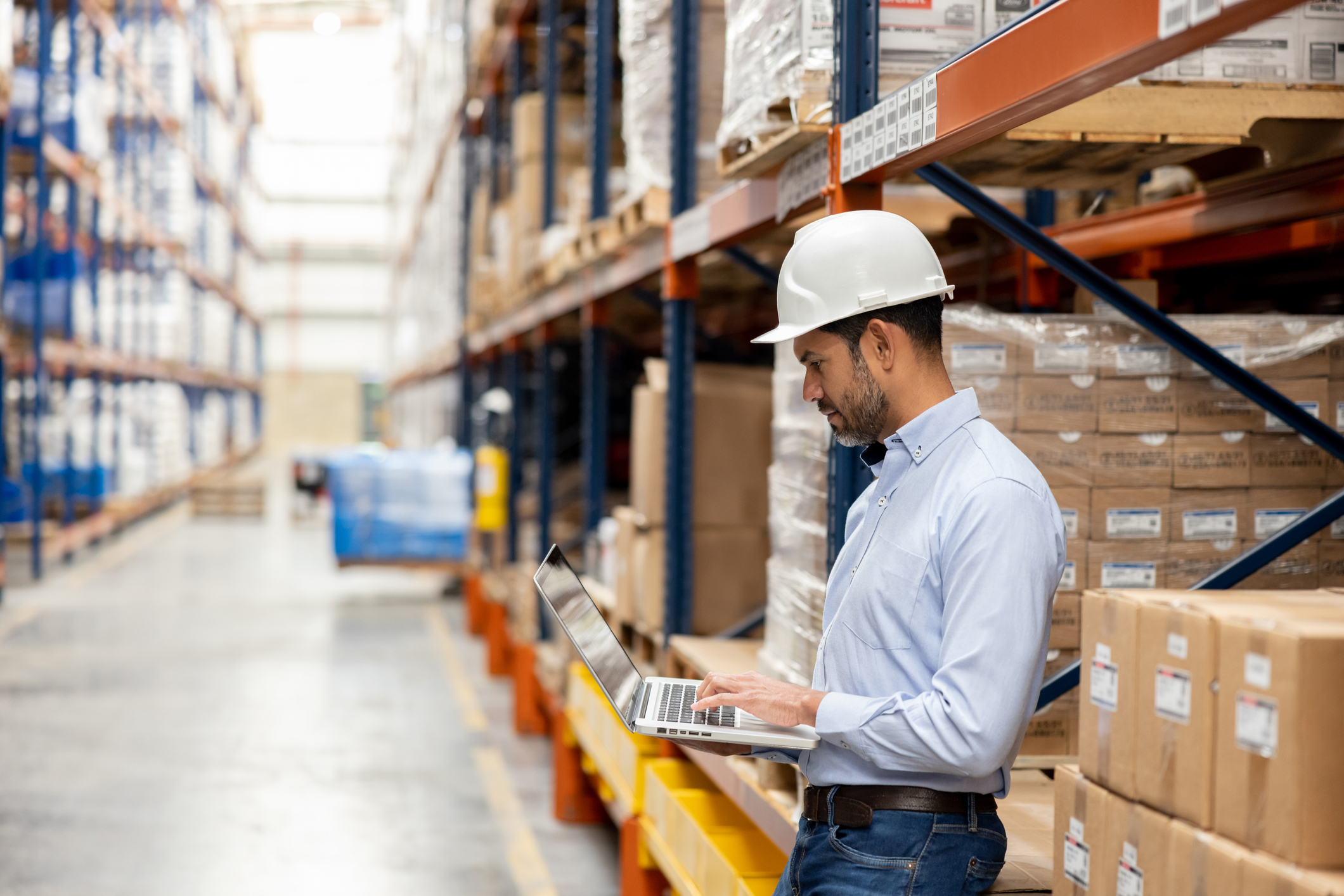 Business man supervising the operation of a distribution warehouse