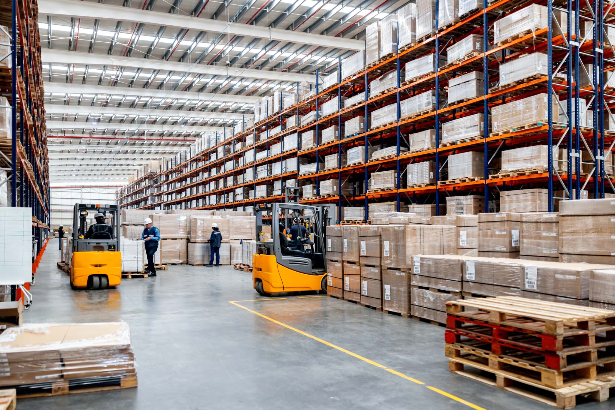 Employees working at an e-commerce warehouse and using forklifts